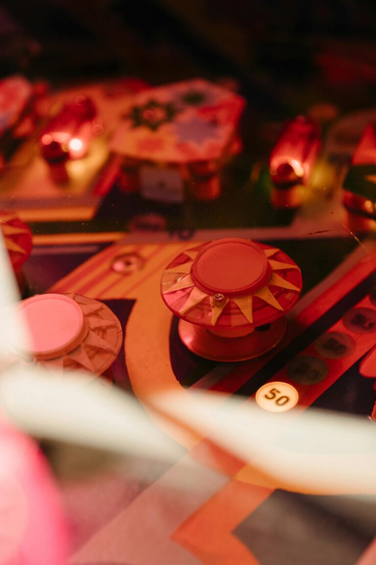 Colorful vintage pinball machine with illuminated bumpers and intricate details.
